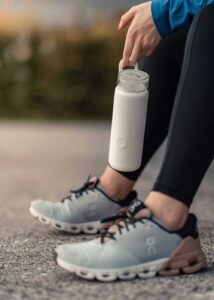 Female runner carries a water bottle to stay hydrated while on a run