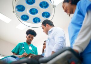 text: one doctor and three nurses working in hospital operating room