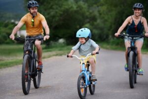 family of mom, dad and young boy going on bike ride together