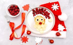 Festive Santa-themed pancake breakfast with fruit and marshmallows, a fun idea for holiday meal planning tips.