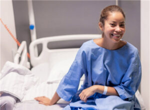 Patient smiling before a colon cancer screening procedure at a medical facility.