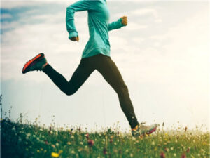 Woman exercising outdoors as part of a healthy lifestyle for colorectal cancer prevention.